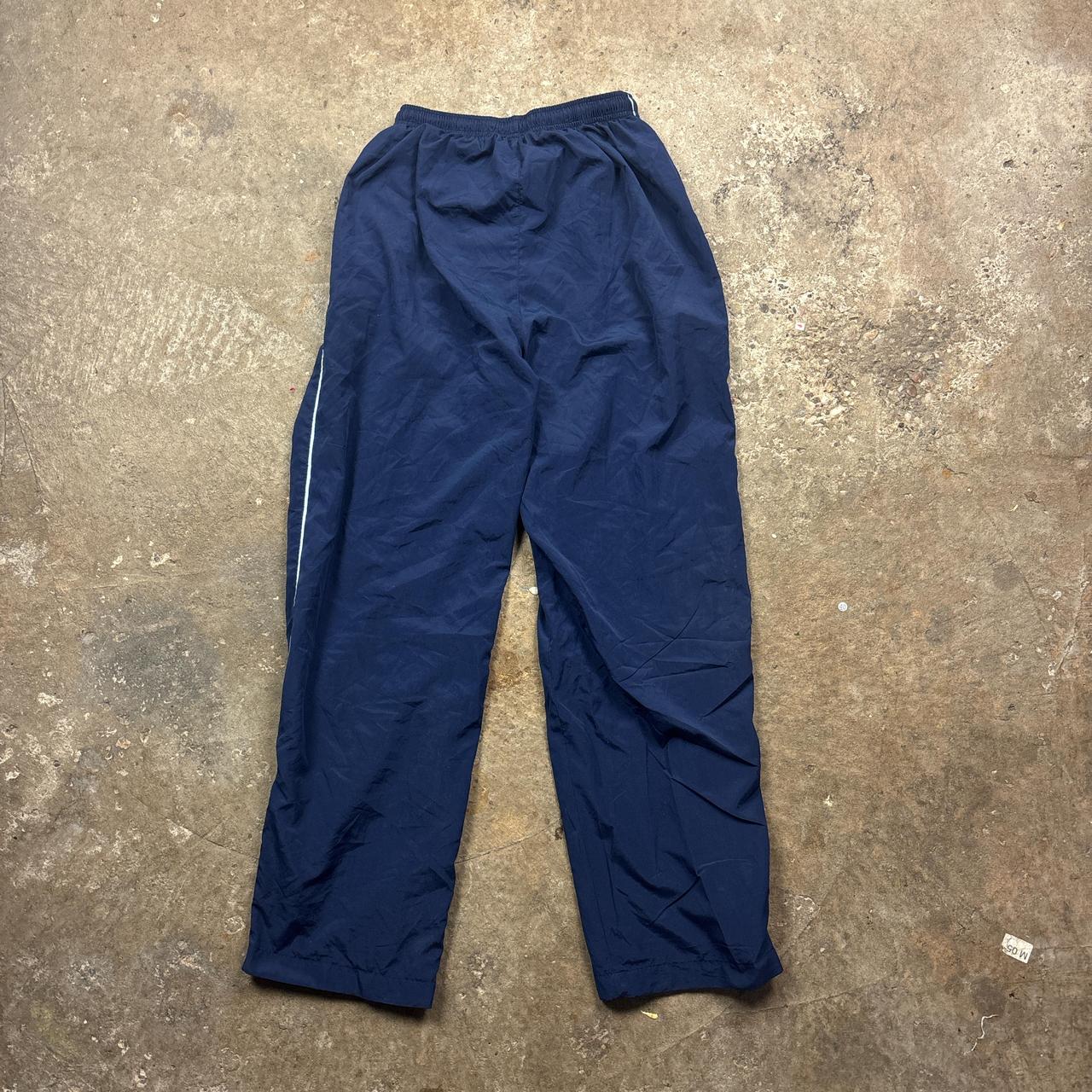 Navy Champion track pants with white stripe and embroidered logo