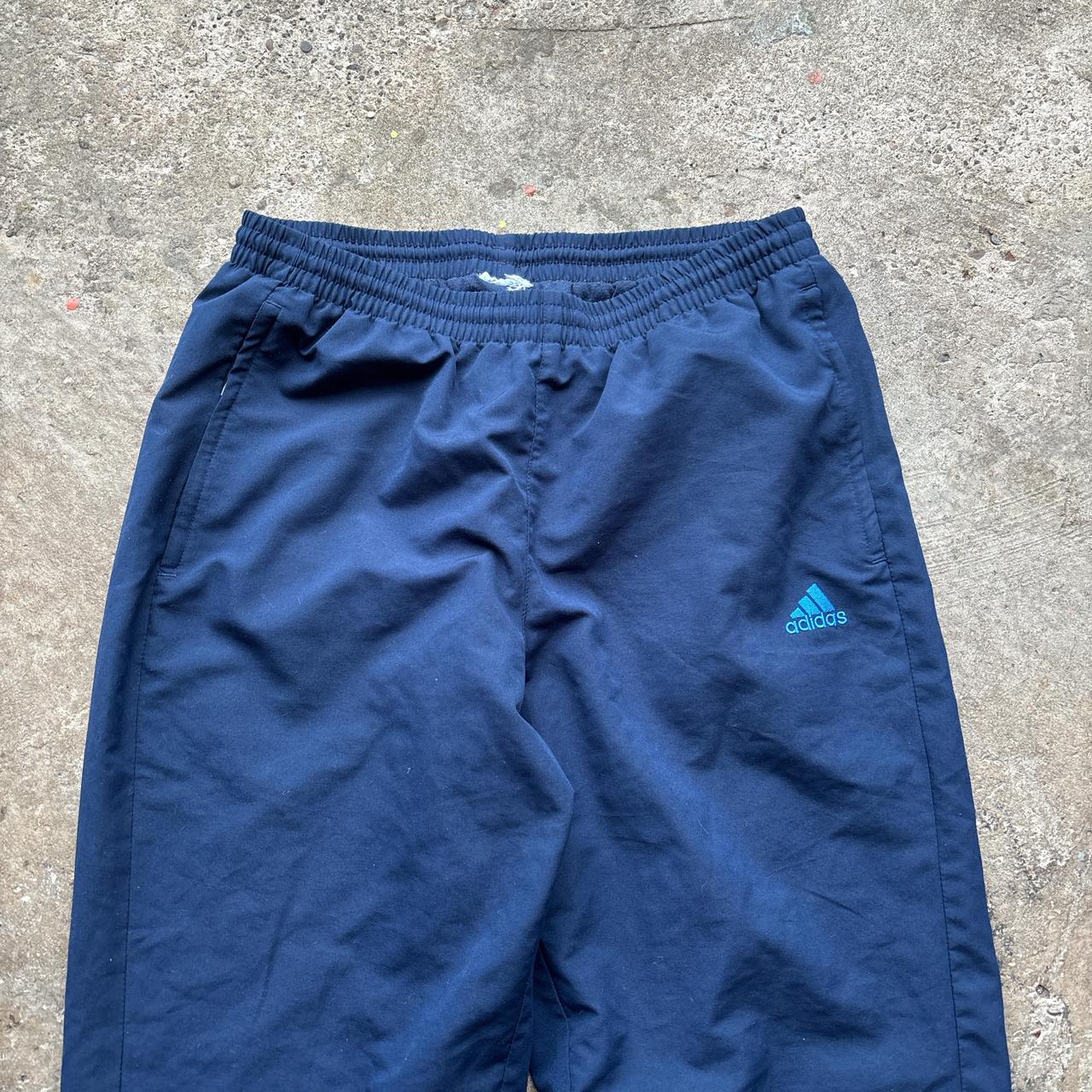 Navy Adidas track pants with blue stripes and embroidered logo