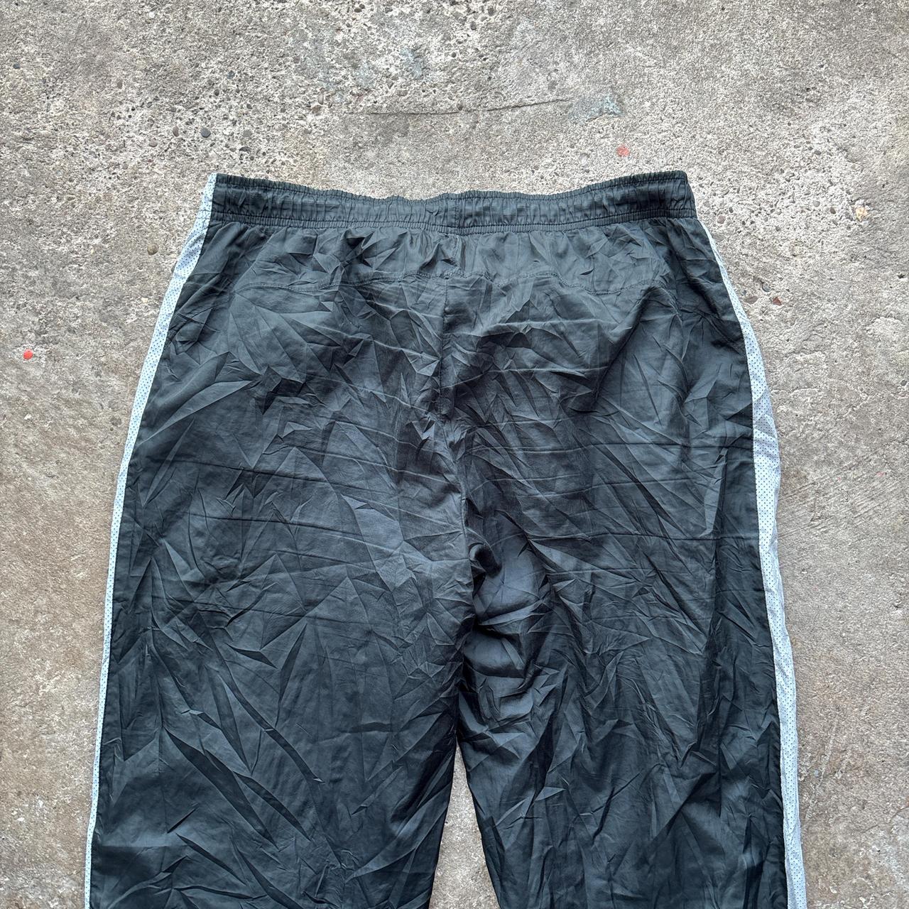 Black 00s Nike track pants with grey side stripe