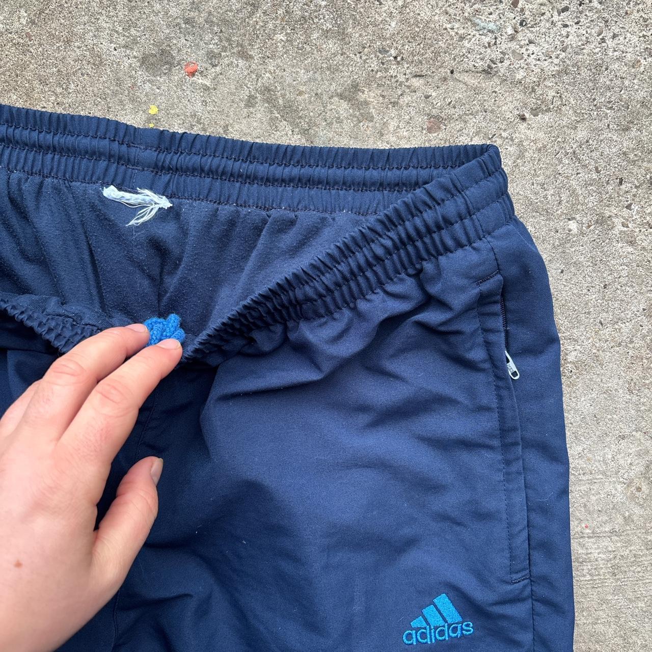 Navy Adidas track pants with blue stripes and embroidered logo