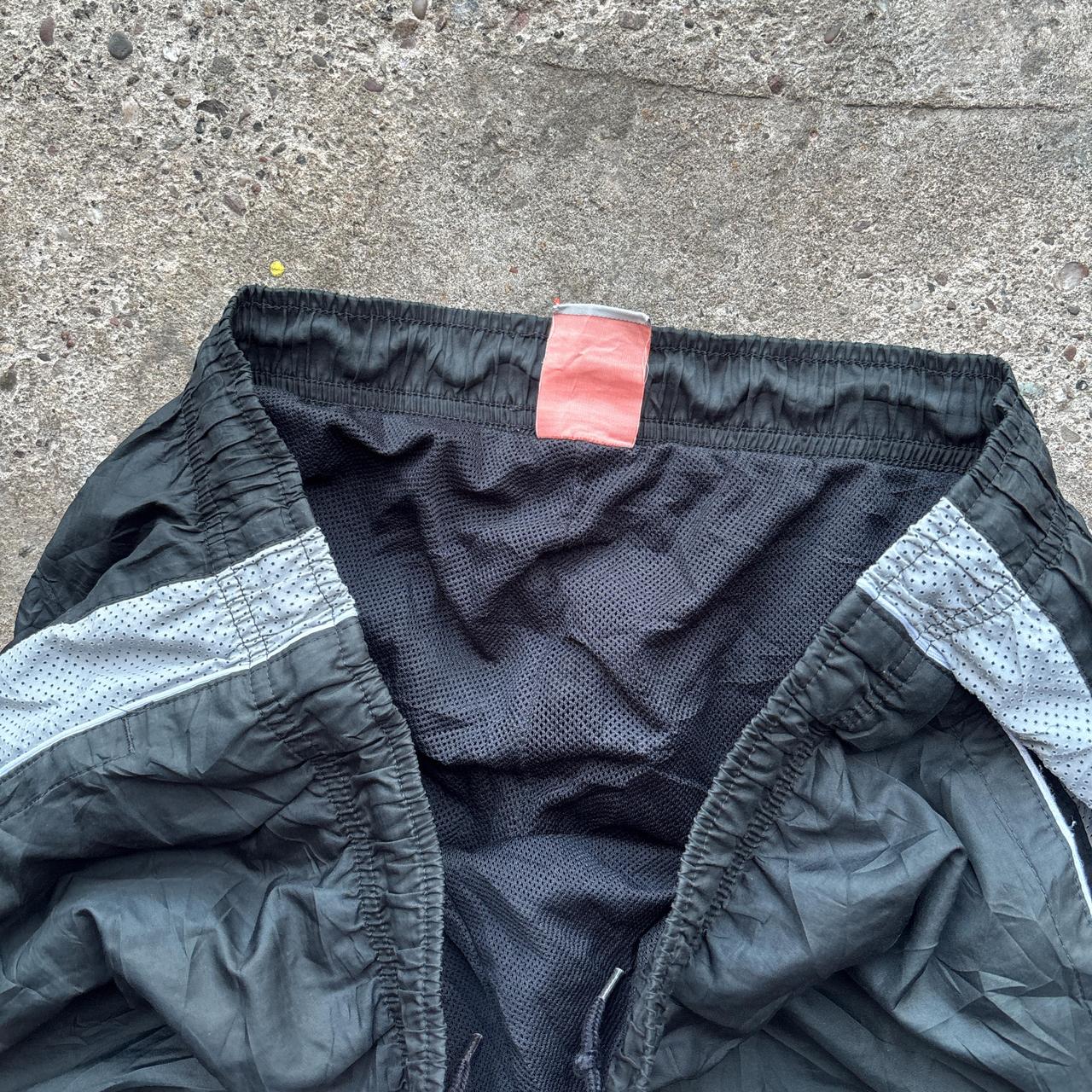 Black 00s Nike track pants with grey side stripe