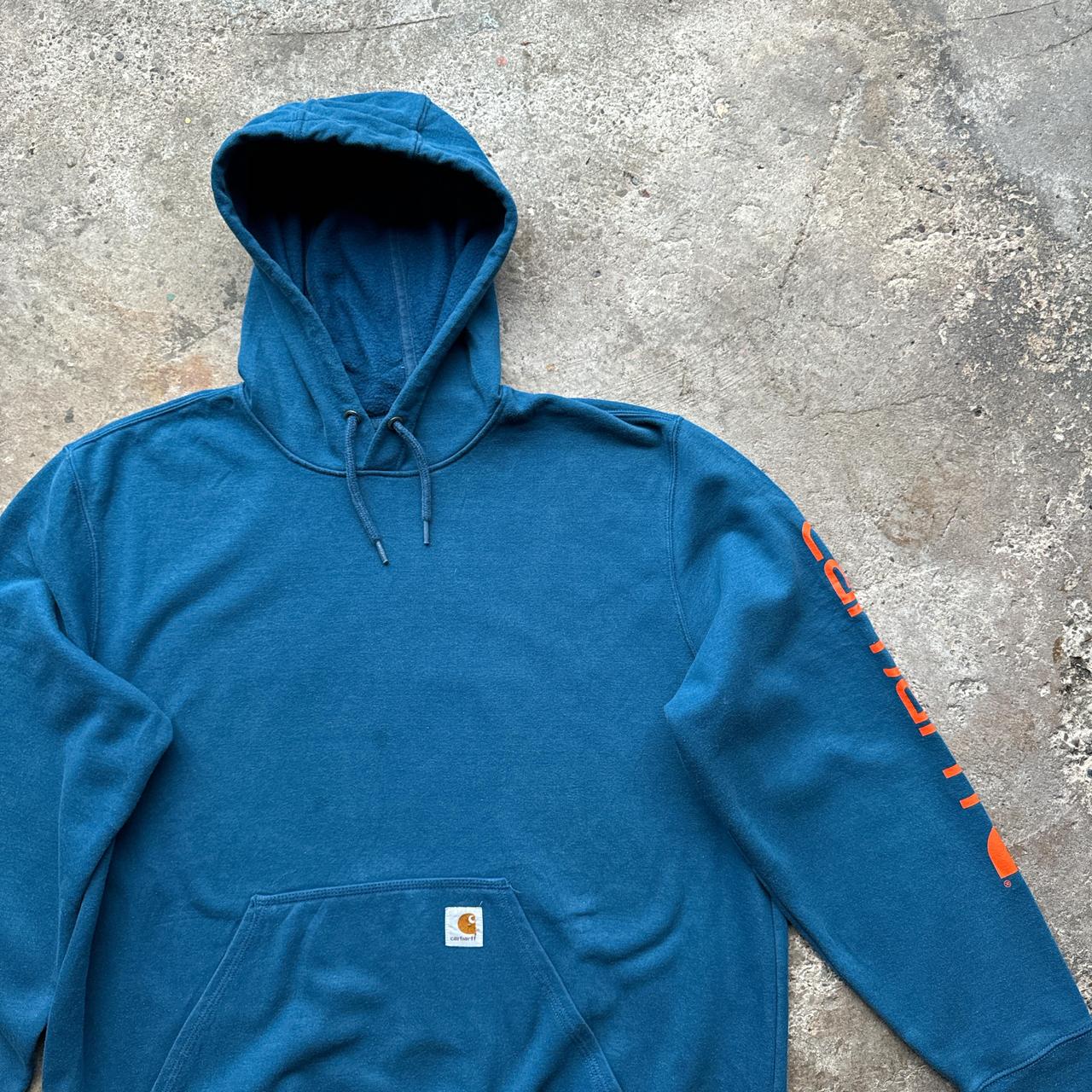 Blue Carhartt hoody with orange print down the sleeve