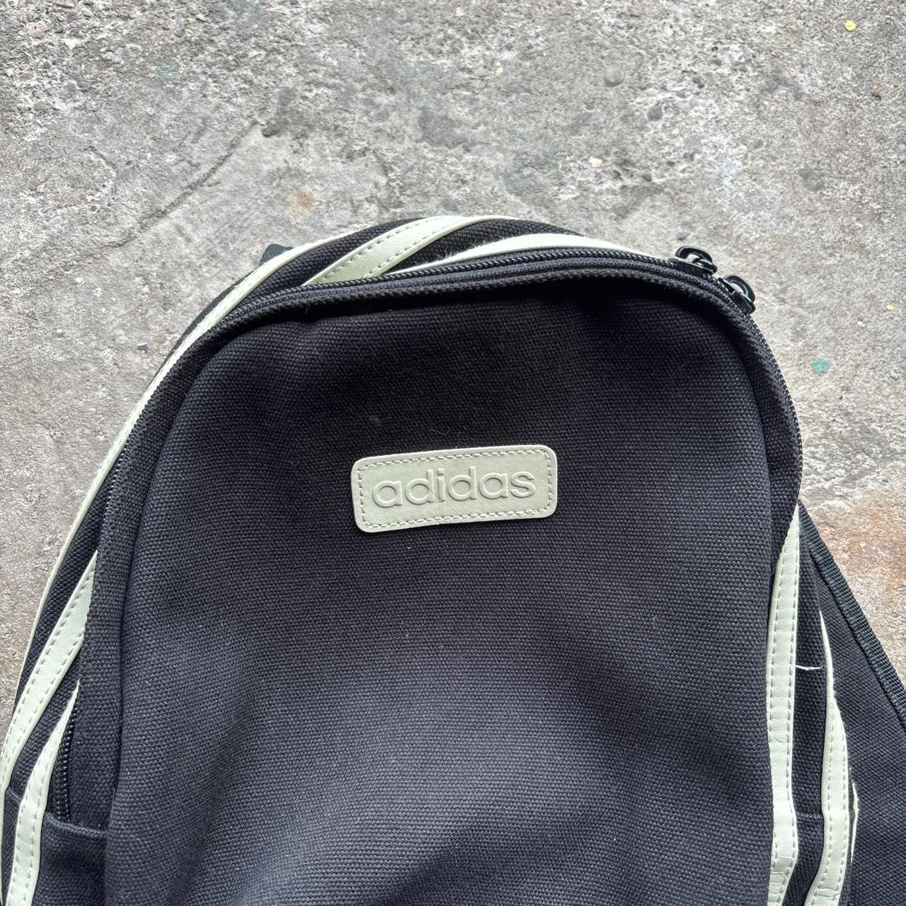 Black Adidas bag with wrap around cream stripes