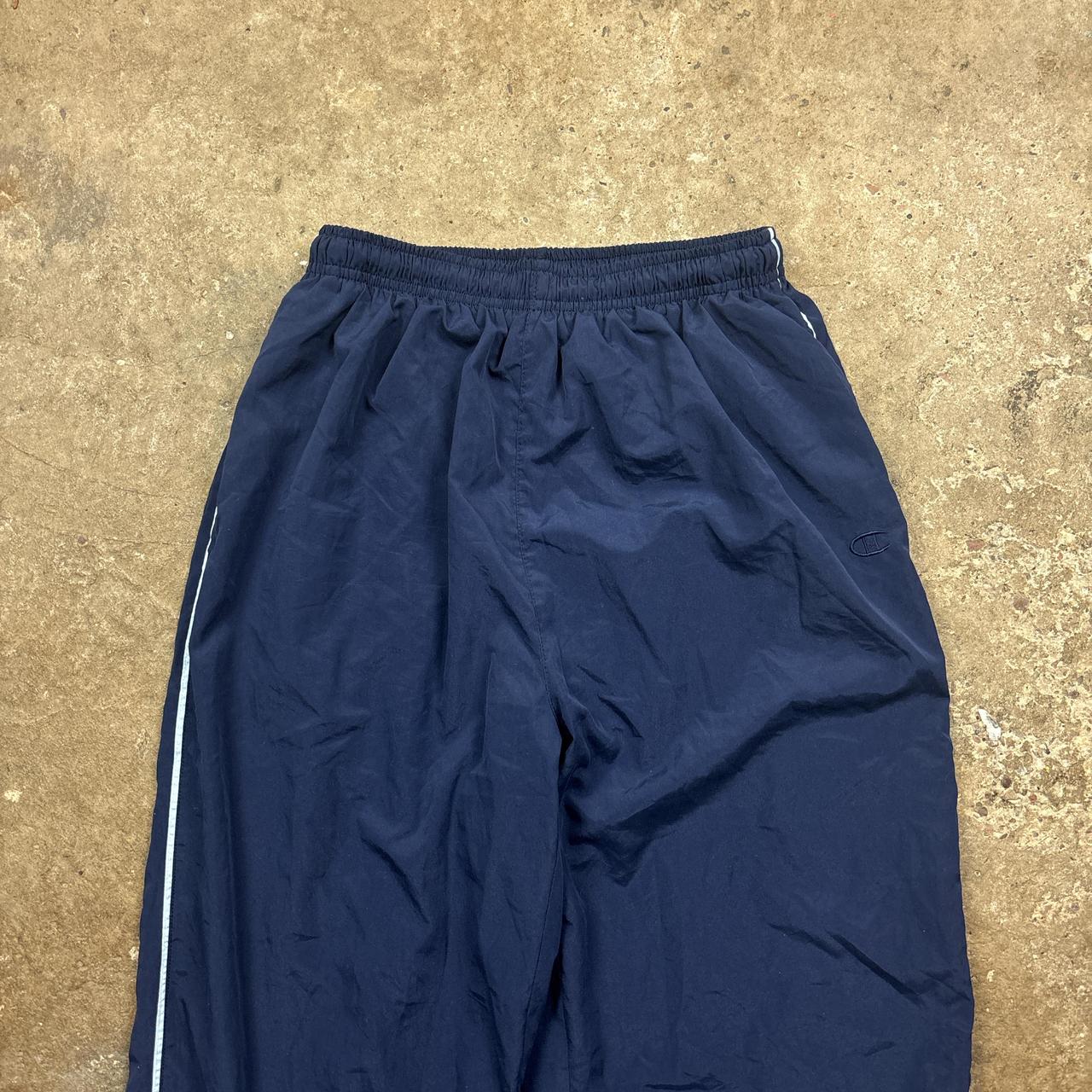 Navy Champion track pants with white stripe and embroidered logo