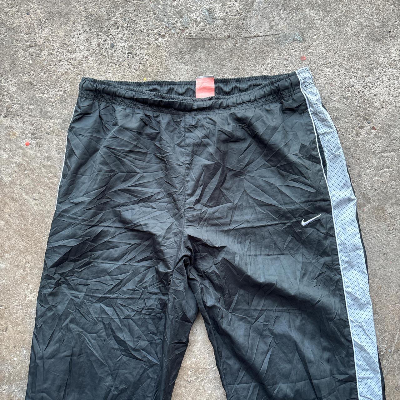Black 00s Nike track pants with grey side stripe