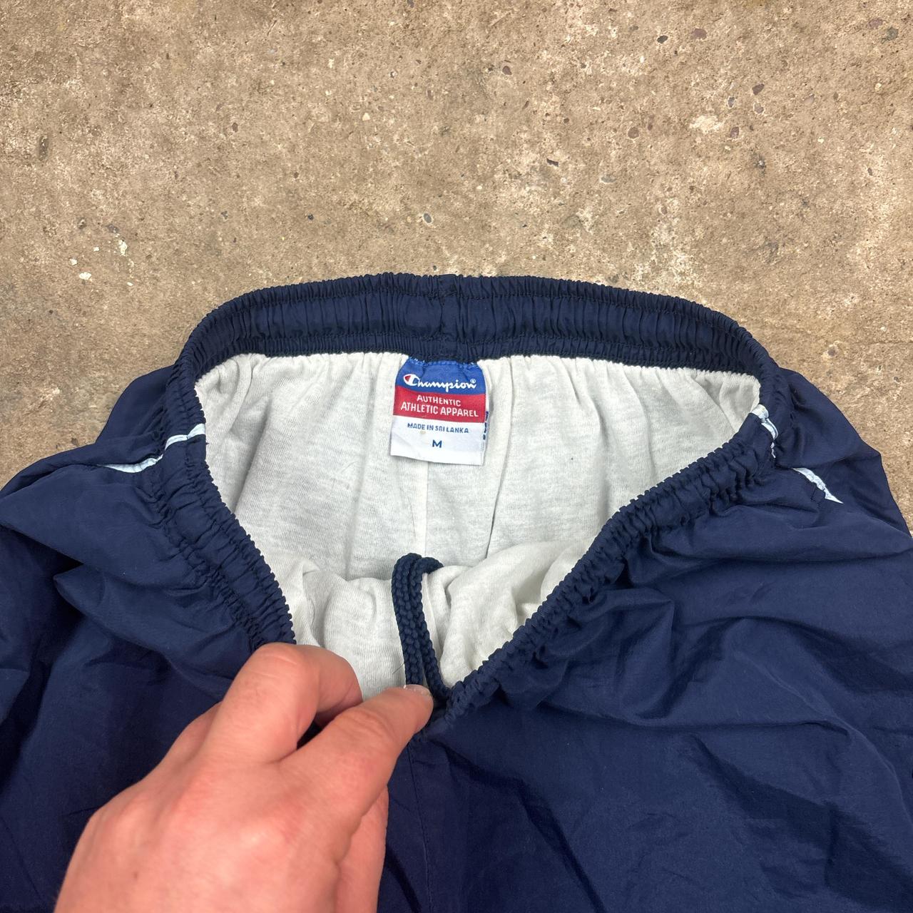 Navy Champion track pants with white stripe and embroidered logo